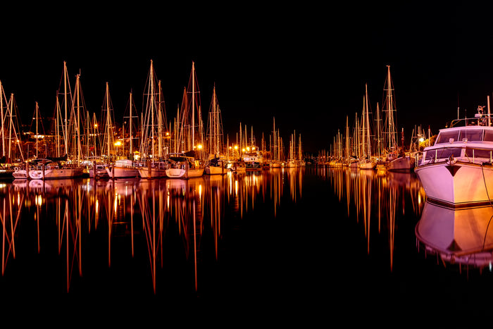 Captivating photograph of sails boats reflected in a harbor to create the waveform of sound waves